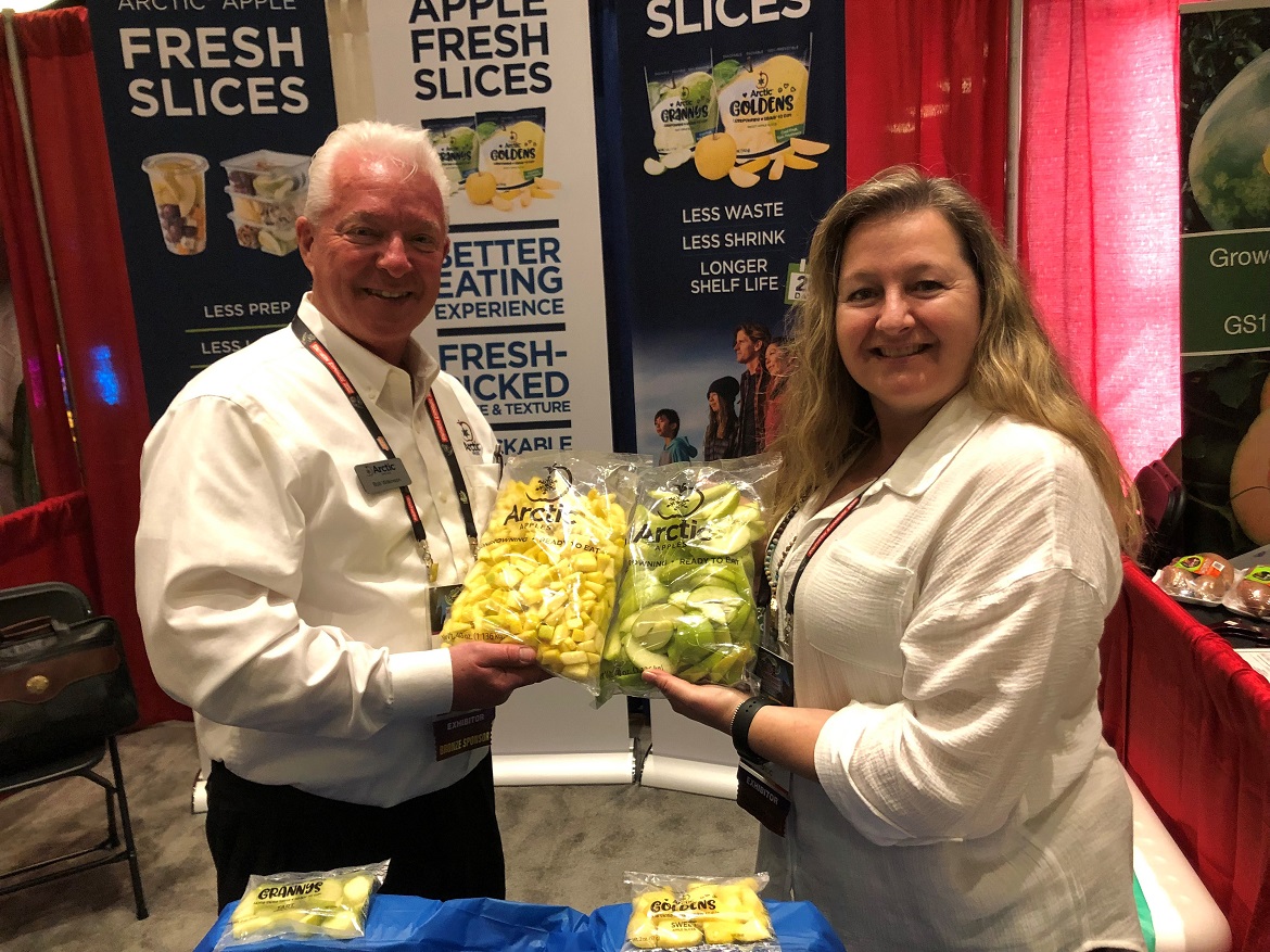  Pictured are Bob Wilkinson, director of sales for Okanagan Specialty Fruits, Summerland, B.C., with Jodi Green, senior marketing manager.
Wilkinson said the company has about 1,350 acres of Arctic apples, or almost 2.7 million trees, in Washington state. The company is marketing all of its nonbrowning apples as fresh-sliced fruit. With refrigeration, the sliced apples boast a 28-day shelf life and are offered in 10-ounce, 5-ounce, 2-ounce and 40-ounce packages. The vast majority of sales are to foodservice, including some military contract business,  but Wilkinson said the company is looking to make inroads with retailers.