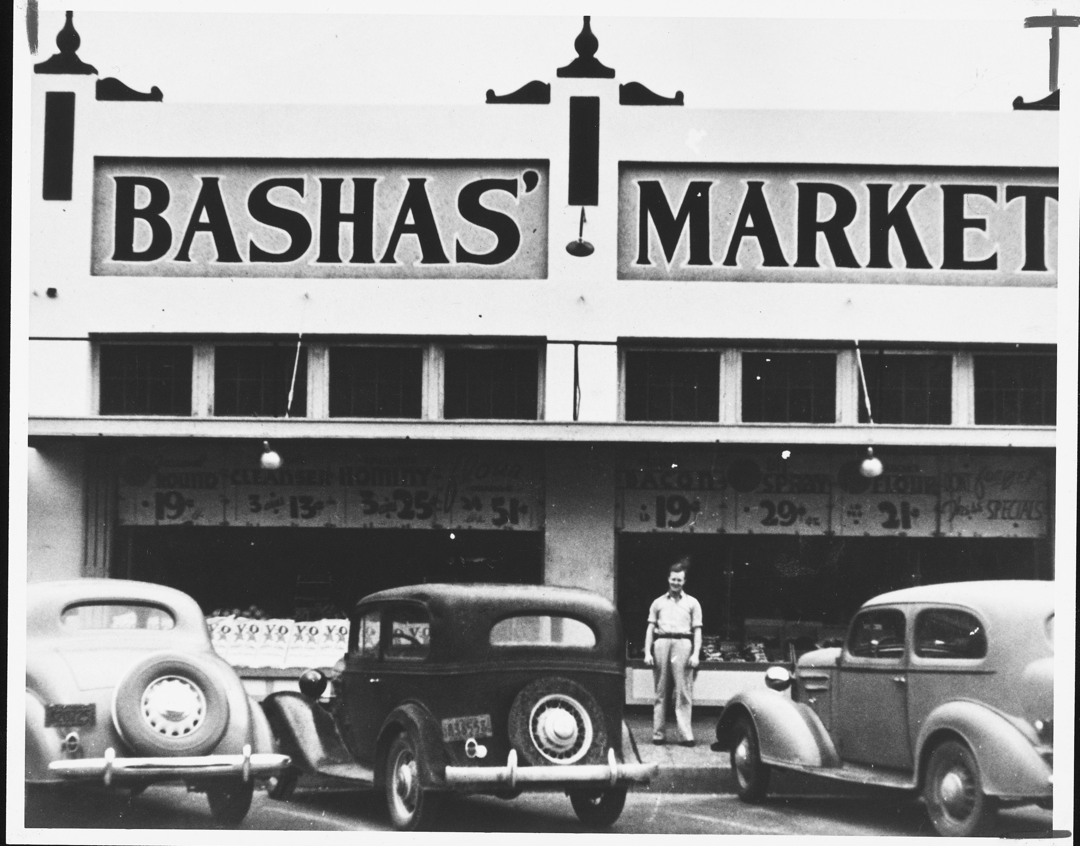  Don Cooper stands outside a Bashas' store, circa early- to mid-1900s.