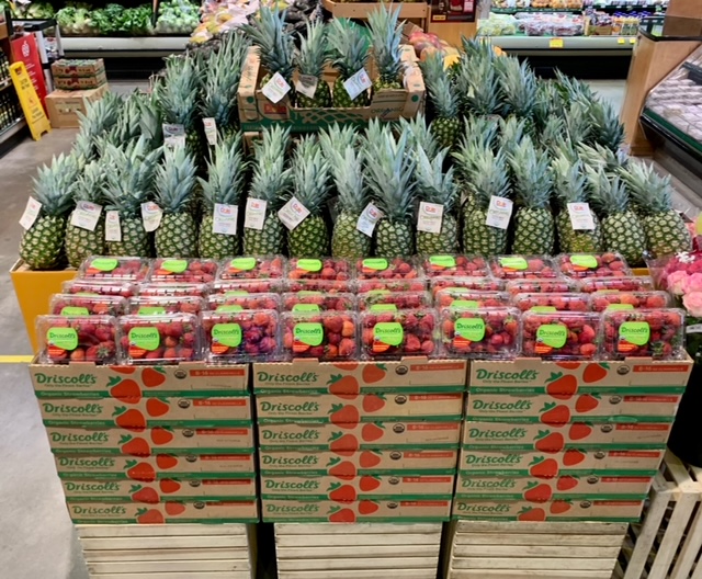   Charlton lifted the strawberries with wooden crates below cardboard boxes, angling the clamshells toward the shopper for the best view. And the pineapple is a great contrast.