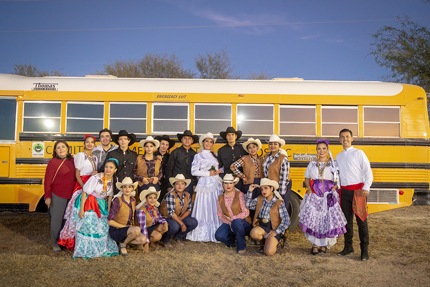  The dance group poses in front of one of the fair trade premium-funded school buses.