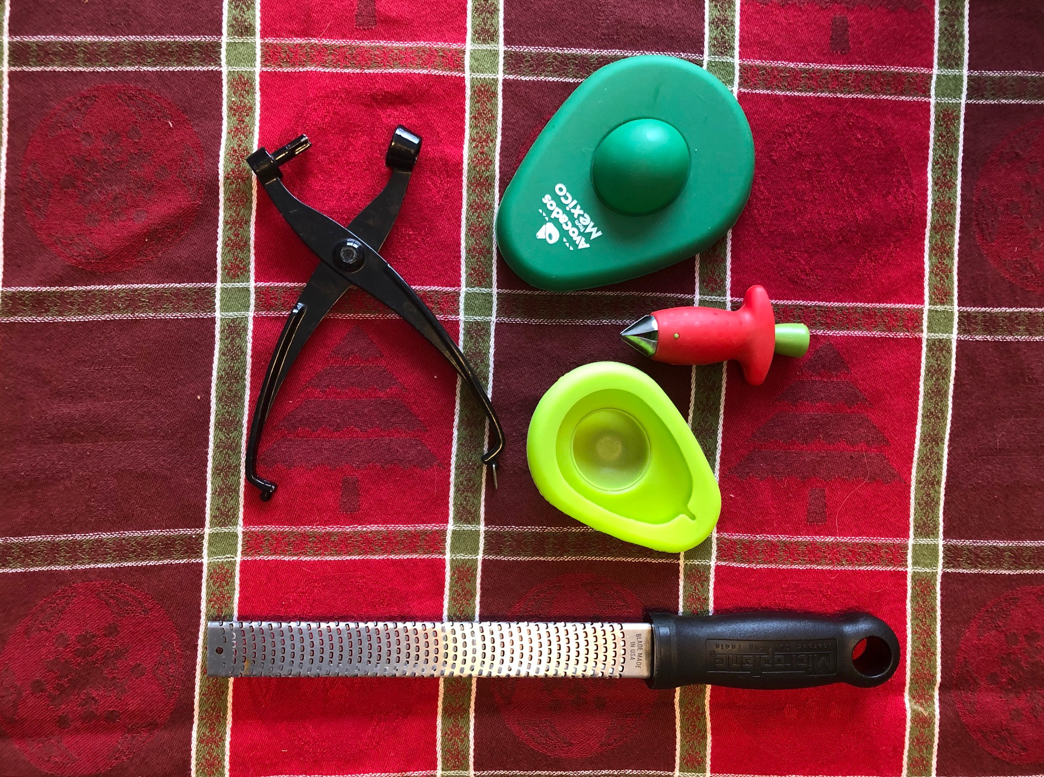 A cherry pitter, an avocado keeper, a strawberry huller and a Microplane.
