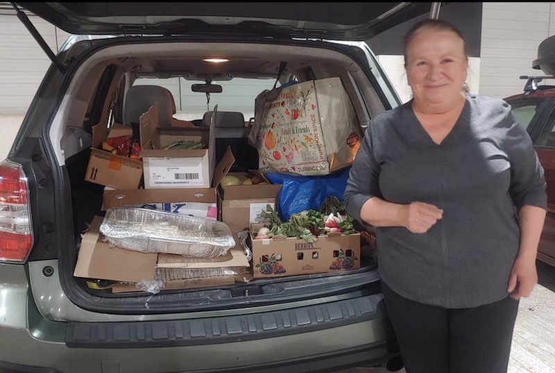 lady with donated food in trunk of car