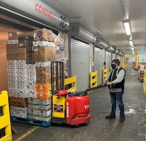 foreman pushes produce boxes on a cart