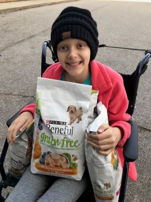 Maddie Barber holding donation of dog food for shelter