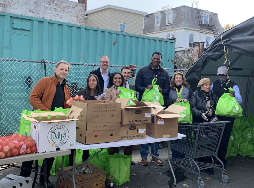 hunts point week of giving volunteers stand with donation bags full of produce