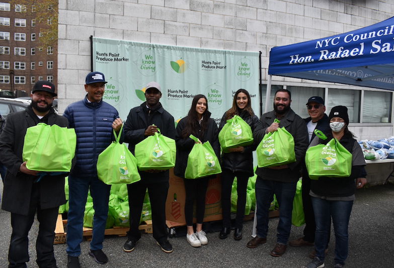 hunts point week of giving volunteers stand with donation bags
