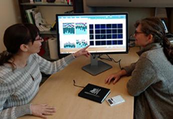 ARS scientists Danielle Lemay (right) and Zeynep Alkan review microscope images and data from SAMSA2 software.