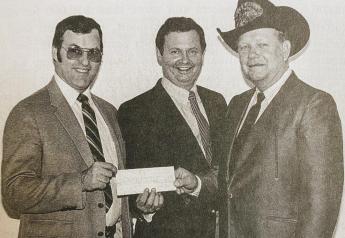 A mix of business and religion: Fred Hendrickson, center, and James Dwire, left, present producer Andy Van Zee with a $500,000 check at the American Energy Farming System’s 1982 convention in Marshall, Minn. 
