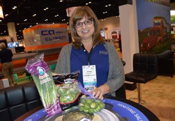 Diana McClean, senior director of marketing for Castroville, Calif.-based Ocean Mist Farms, displays several new products at the company’s Fresh Summit booth.
