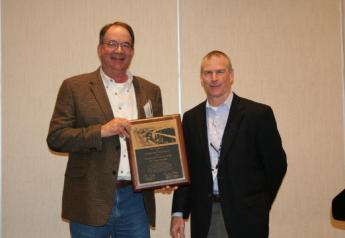 Zoetis technical-services veterinarian Mitch Blanding (right) presents Dr. Weaver with the Consultant of the Year Award.