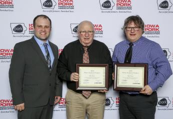  (l to r) Ben Schmaling, president of the Iowa Purebred Swine Council, presents the 2019 Master Seedstock Award to Bill Owens and Bob Owens.