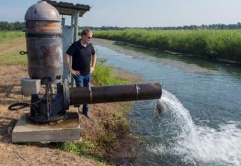 Arkansas rice producer Mark Isbell watches water pump into one of his fields.