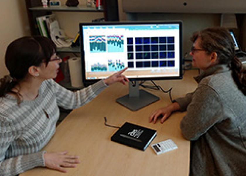 ARS scientists Danielle Lemay (right) and Zeynep Alkan review microscope images and data from SAMSA2 software.