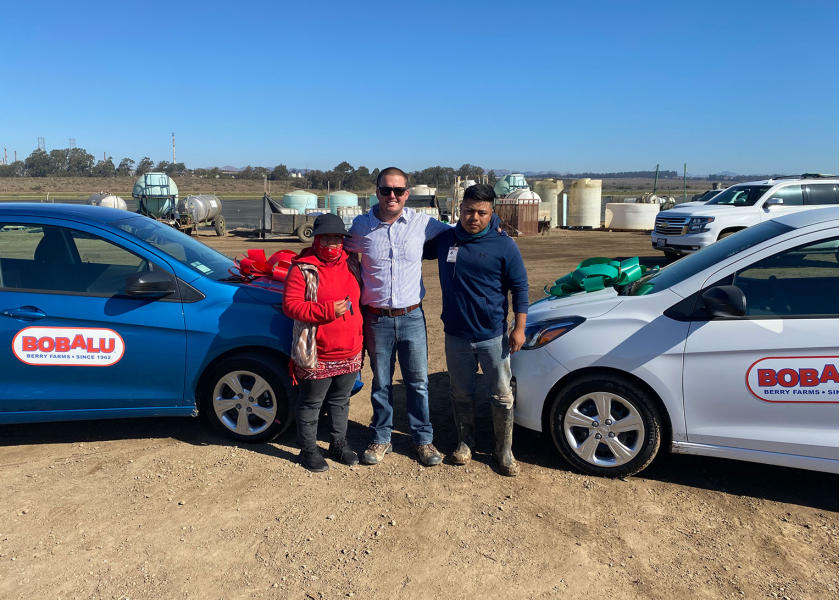 RC Jones (center), managing member of Bobalu Berry Farms, with workers Guillermo and Eva, who won cars at the company's end-of-season celebration for strawberries.