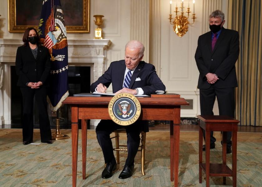 U.S. President Joe Biden signs executive order as Vice President Kamala Harris and White House science adviser Eric Lander standby in the State Dining Room at the White House in Washington, U.S., January 27, 2021. REUTERS/Kevin Lamarque
