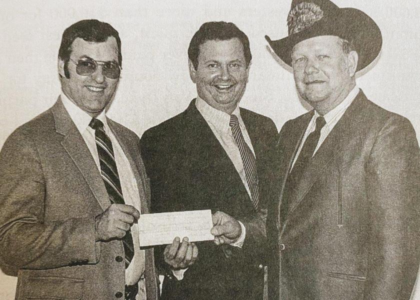 A mix of business and religion: Fred Hendrickson, center, and James Dwire, left, present producer Andy Van Zee with a $500,000 check at the American Energy Farming System’s 1982 convention in Marshall, Minn. 
