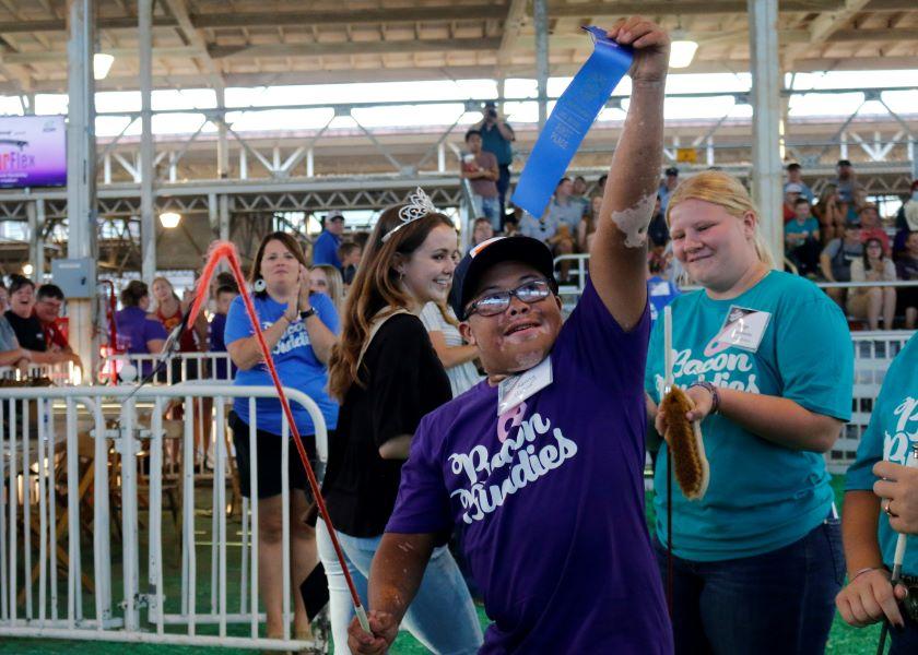 Kenny Hollins celebrates after receiving a first-place ribbon for showing a pig during the Bacon Buddies swine show at the Iowa State Fair.
