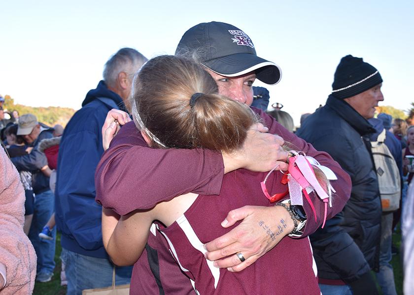 Unity Cross Country Coach Kara Leaman hugs runner Olivia Shike after the race.