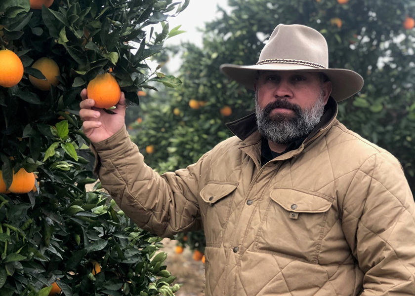 Ryan San Jose, sales manager for Klispell, Mont.-based Access Organics, checks on the progress of navel oranges from Fresno, Calif.-based Benzler Farms. Access Organics markets Benzler Farms brand navel and valencia oranges, grapefruit, lemons and mandarins.