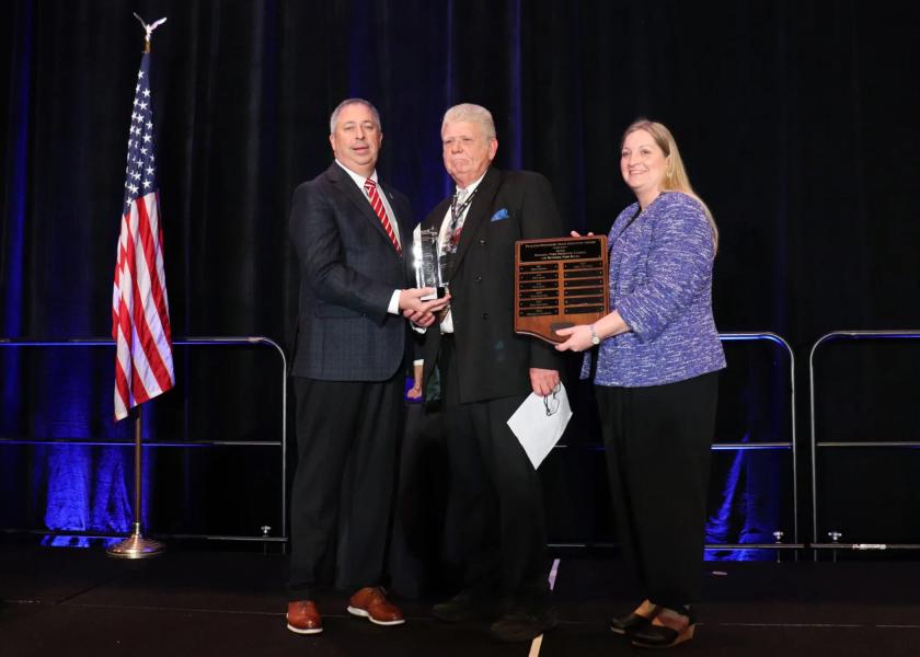 Former Iowa Pork Producers Association Executive Director Mike Telford (center) receives the Paulson-Whitmore State Executive Award from NPPC President Terry Wolters (left) and National Pork Board President Heather Hill.