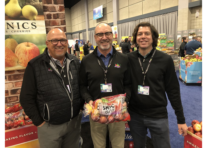 From left, Chuck Sinks, president of sales and marketing at Sage Fruit Co. Yakima, Wash.; Tim Colln, vice president of sales and marketing; and Kevin Steiner, director of business development, display a 5-pound bag of Cosmic Crisp apples at the March 20-22 Associated Wholesale Grocers Innovation Showcase in Overland Park, Kan.