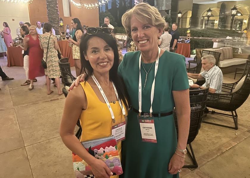 Cecilia Flores Paez, head of marketing at T&G Global Ltd. and its Envy apple brand, and Cathy Burns, CEO of International Fresh Produce Association, attend the opening networking party at Produce for Better Health's Consumer Connection Conference in Scottsdale, Ariz.