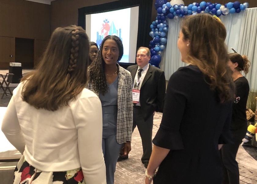 Hockey star and keynote speaker Blake Bolden talks with people after her keynote address at the NEPC conference on Aug. 25, 2022.
