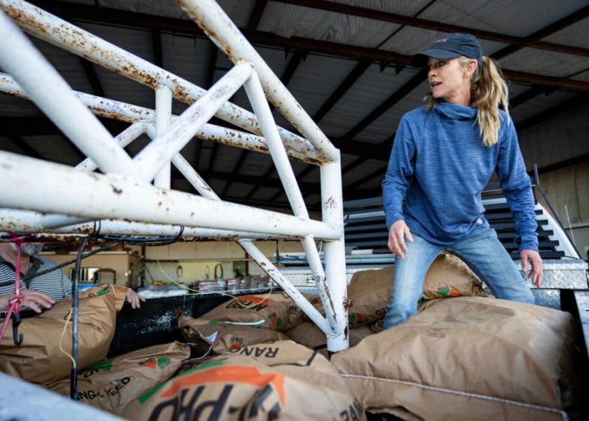 Texas A&M AgriLife extension agent Megan Eikner loads bags of feed onto trucks at the Animal Supply Point in Borger.