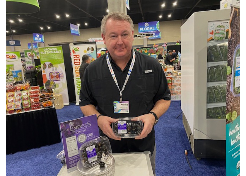 Harold Paivarinta, senior director of sales for Red Sun Farms, displays the Norfolk Healthy Produce purple tomato pack at the Associated Wholesale Grocers' seventh annual Innovation Showcase in Overland Park, Kan.