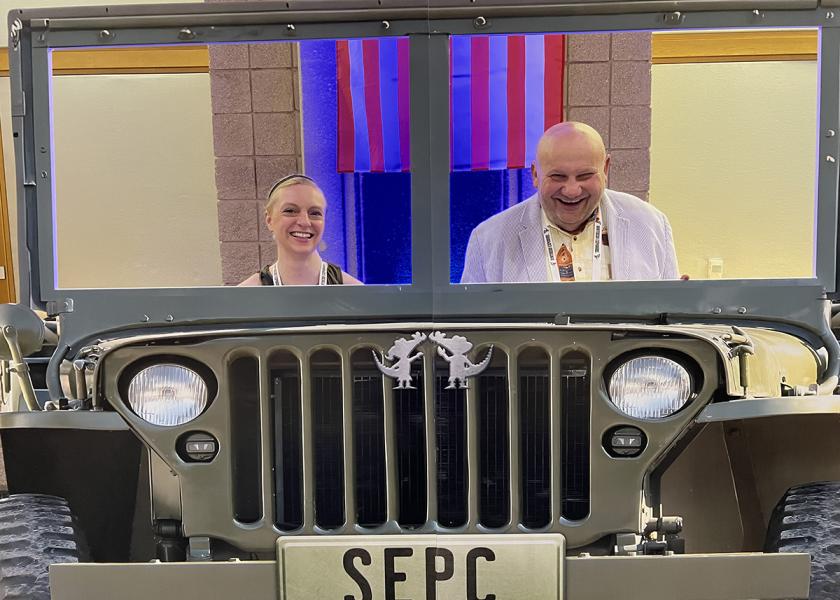 The Packer's Christina Herrick and The Fresh Market's Dennis Payne take a "spin" in a cardboard jeep at SEPC's Southern Exposure 2024, which featured the theme, "Produce: The Unseen Heroes."