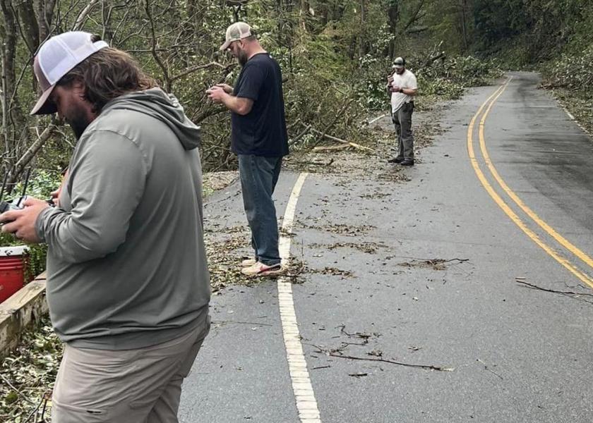 Producer Russell Hedrick, middle, operates a drone to deliver relief supplies in North Carolina.