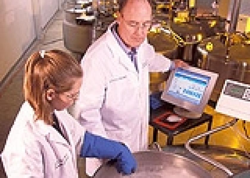 National Animal Germplasm Program coordinator Harvey Blackburn and technician Ginny Schmit place germplasm samples into a liquid nitrogen tank for long-term storage.