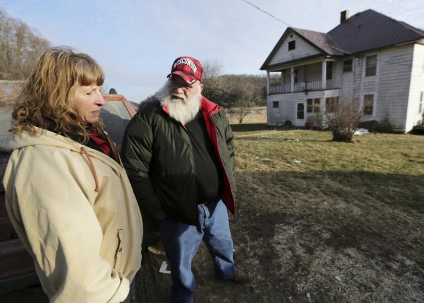 Julie and Phil Henneman, who lost their son Keith to suicide in 2006, when he was 29, talk about the experience outside the old farmhouse in Boscobel, Wis. The Hennemans continue to live on the 215-acre farm with two other sons, but they aren't farming.