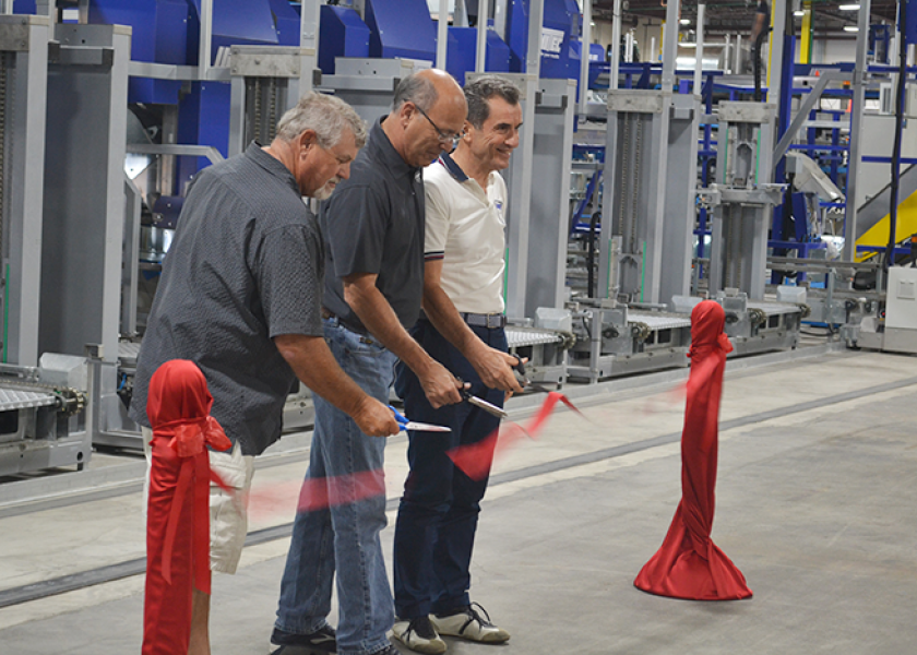 Scott Halliday (from left), Diamond Fruit Growers chairman, David Garcia, Diamond president, and Angelo Benedetti, CEO of Unitec, cut the ribbon July 16 at the unveiling of a special pear packing line at the Diamond Fruit packing facility in Hood River, Ore.
