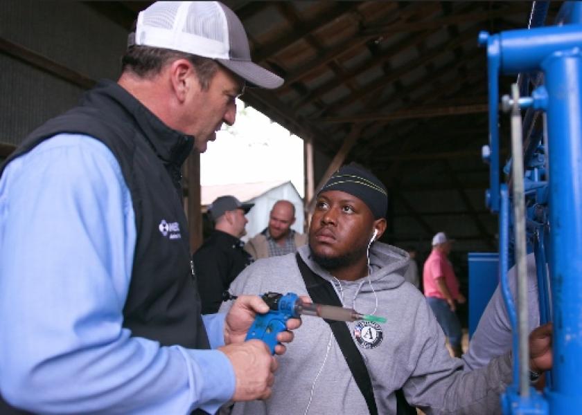 Tim Parks, D.V.M., Merck Animal Health, instructs a service member in proper vaccination techniques.