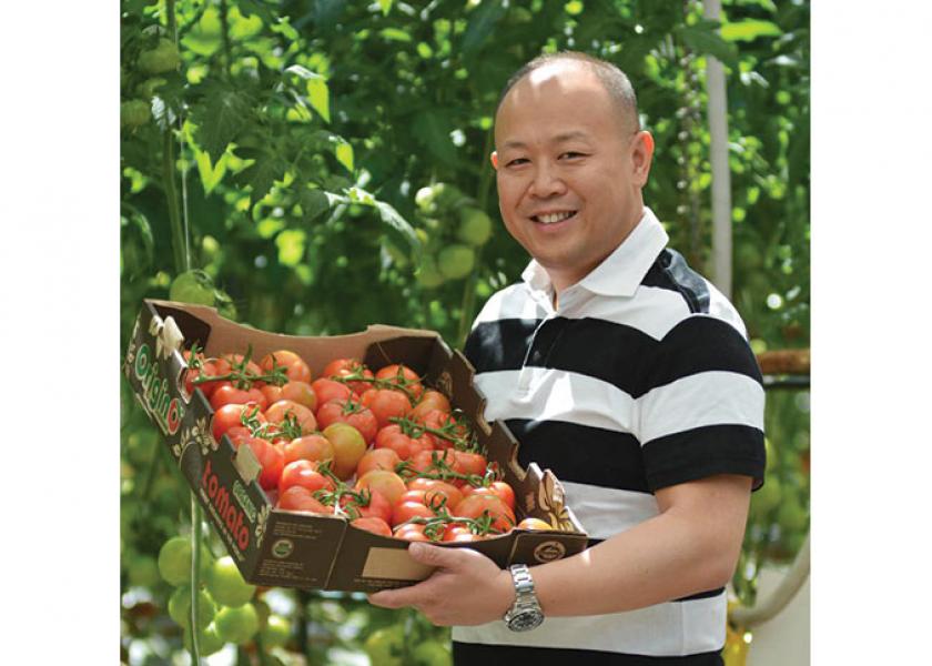 Raymond Wong, founder of Origin Organic Farms Inc., shows some greenhouse-grown tomatoes marketed by The Oppenheimer Group. Grower-shippers say greenhouse products are becoming more popular as consumers adopt more healthful eating habits.