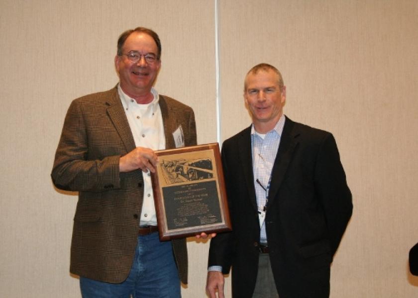 Zoetis technical-services veterinarian Mitch Blanding (right) presents Dr. Weaver with the Consultant of the Year Award.